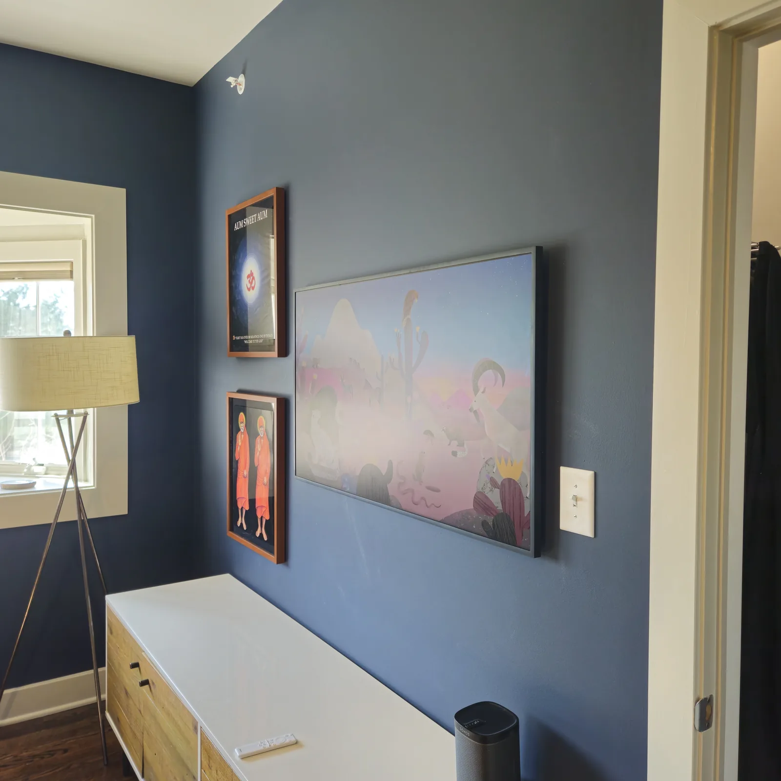 Wall-mounted television above a light-colored media cabinet and small decor.